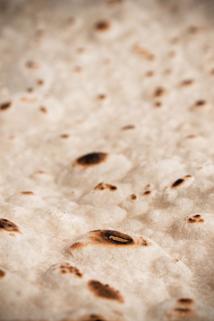 Detailed close-up of freshly cooked Turkish flatbread with golden brown spots, showcasing texture.
